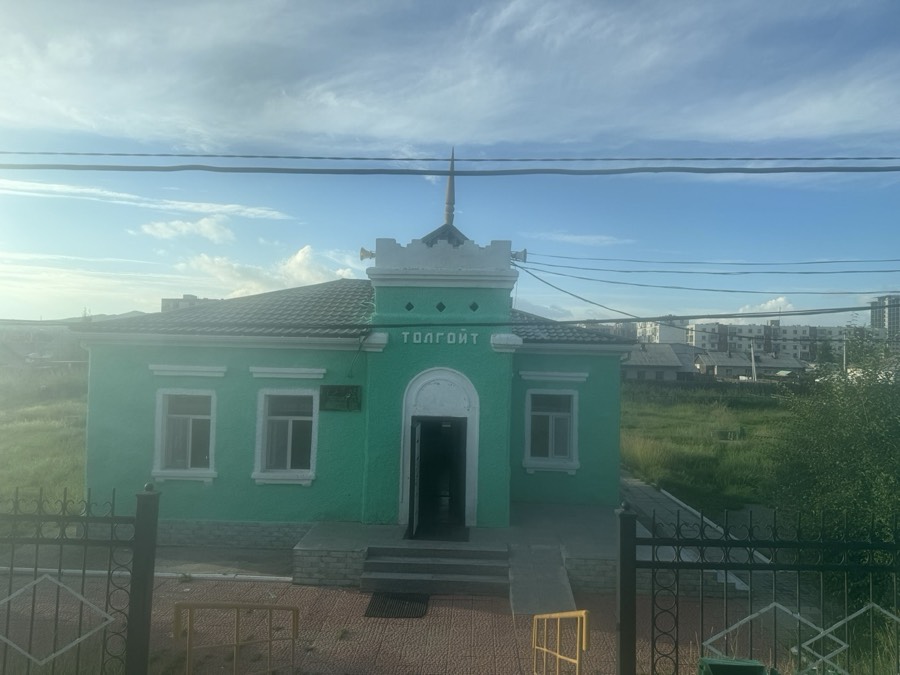 線路ぎわに建つ緑色の小さな駅舎。看板に「トルゴイト」